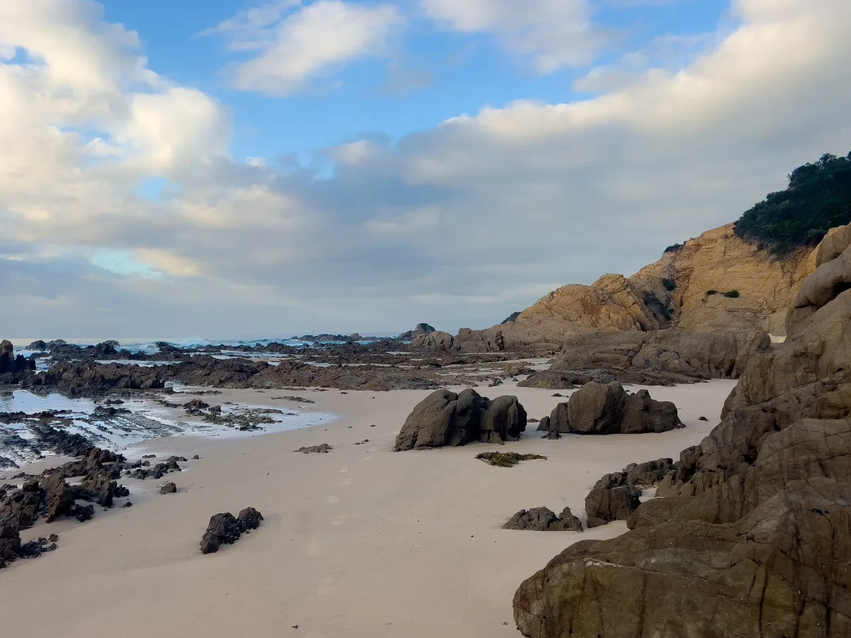 The sandy beach and the rocky cliffs meet at Corunna.