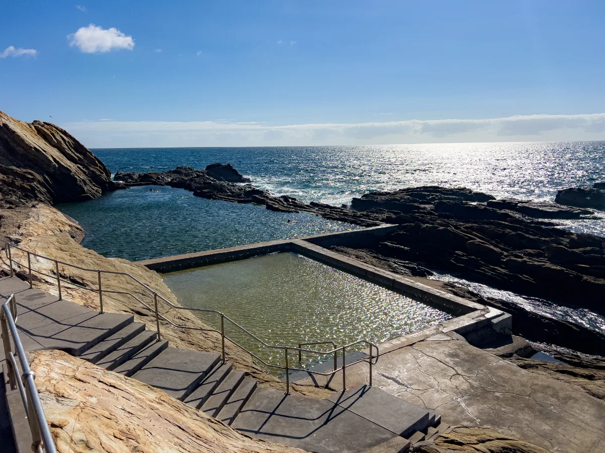 The smaller pool offers a shallow and serene alternative to its larger counterpart.