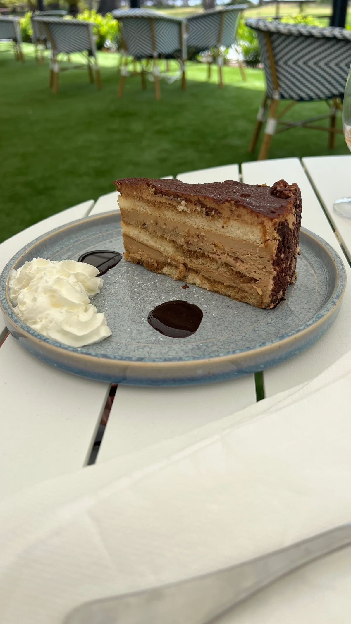 Layered mocha cake with a creamy side.
