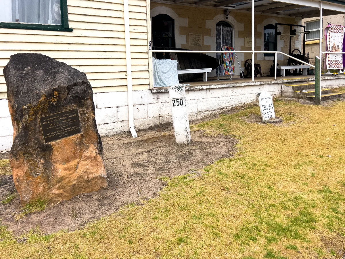 A historical marker and old milepost, carefully preserved.