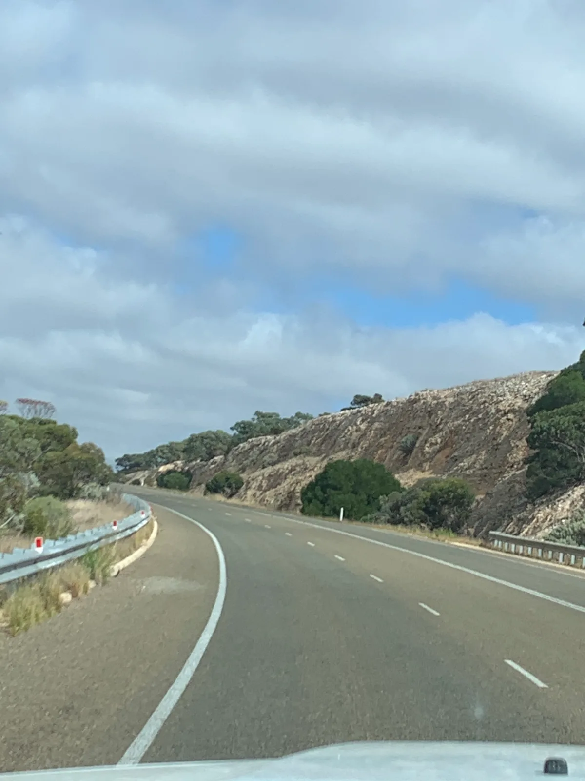 The road cuts through the low, rocky hills of the Madura Pass.
