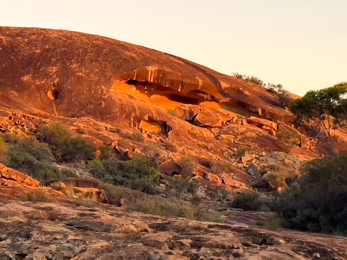 Baladjie Rock rises majestically from the surrounding scrub, its surface etched with the marks of time.