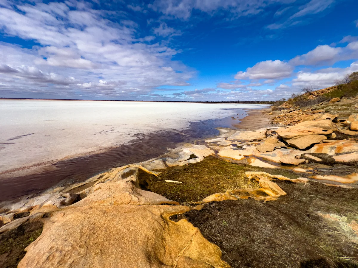 The meeting point of the salt lake and rocky shoreline creates a striking contrast.