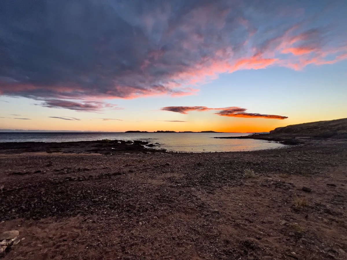 Dramatic pre-dawn colors illuminate a secluded coastal bay