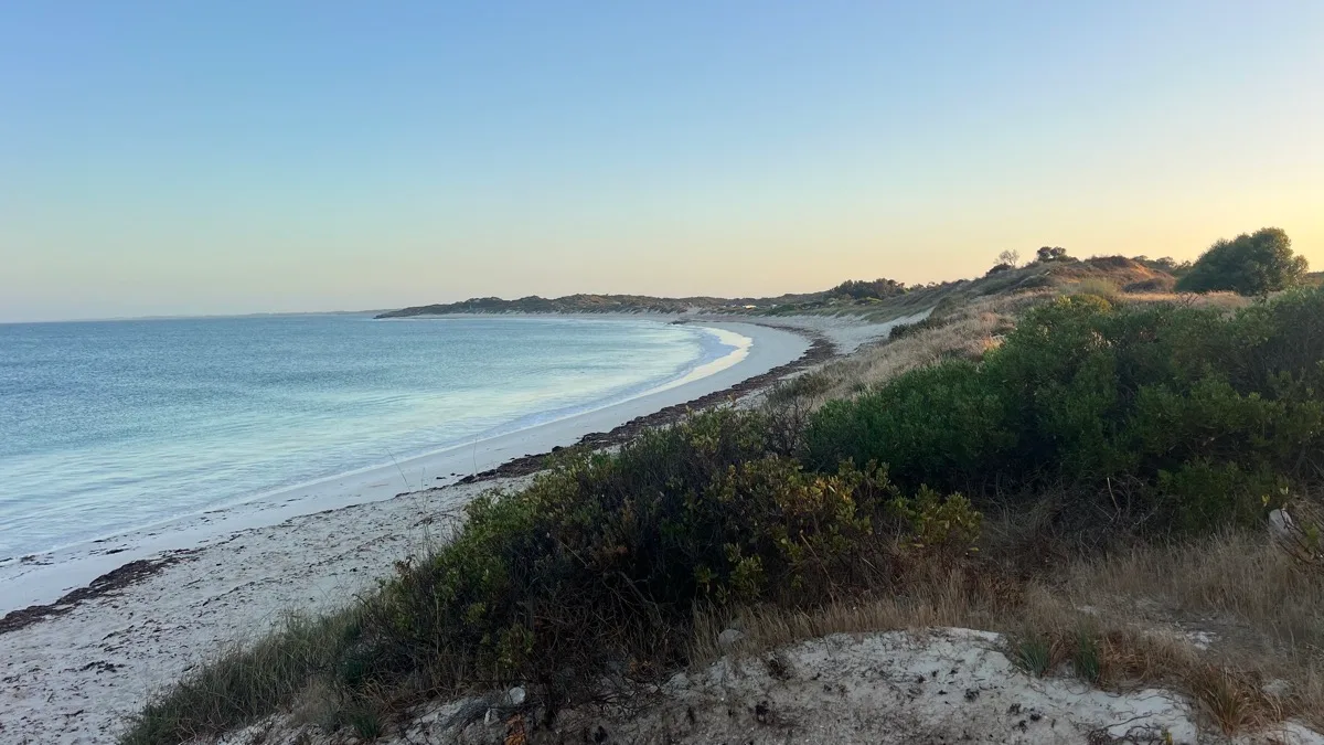 Pristine curved beach with turquoise waters at twilight