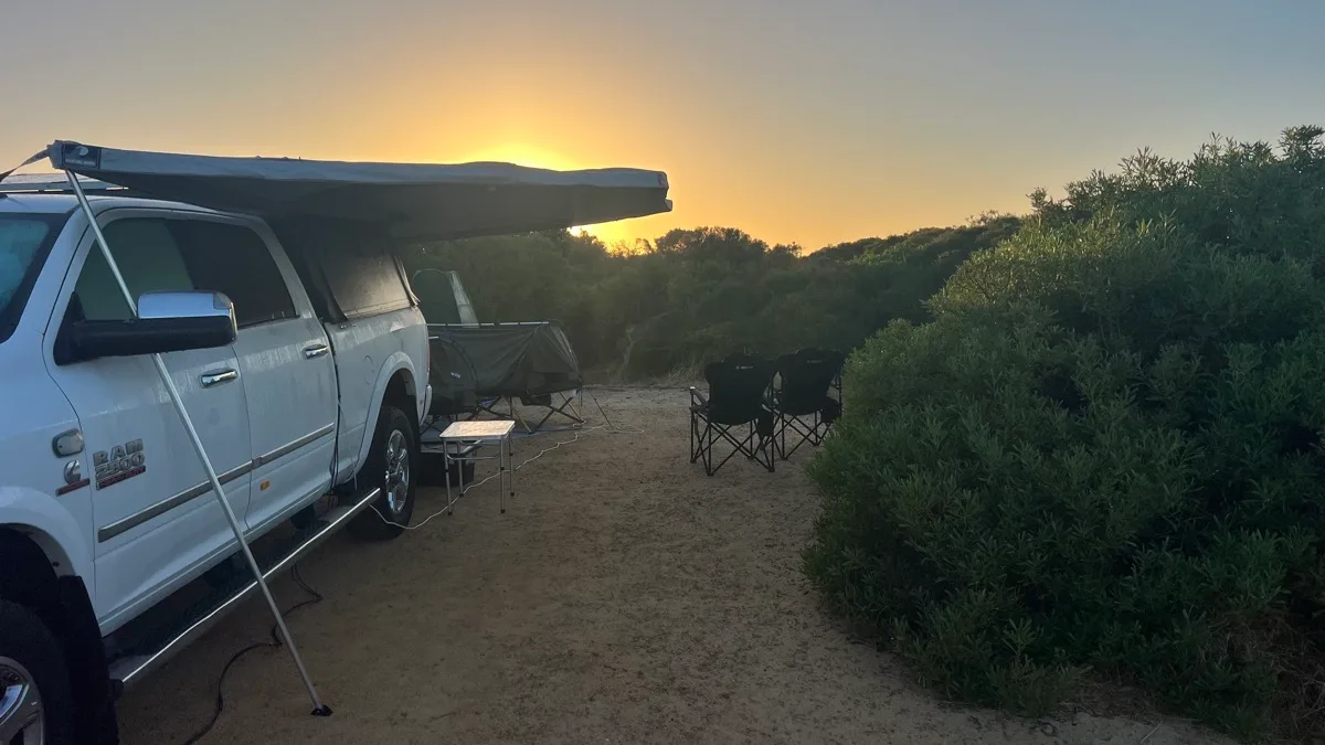 Sunset bush camp with awning setup near coastal scrub